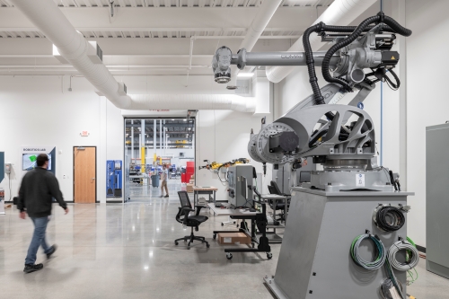 manufacturing floor with a large robotic machine with one large arm 